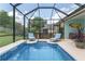 Inviting pool area with lounge chairs, screened enclosure, and mature landscaping providing a serene escape at 12804 Se 90Th Court Rd, Summerfield, FL 34491
