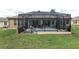 Full view of screened-in pool with inviting lounge chairs, surrounded by green grass and mature landscaping, creating a backyard oasis at 12804 Se 90Th Court Rd, Summerfield, FL 34491