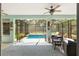 Covered lanai featuring a sparkling pool, comfortable seating area, and a ceiling fan for those hot summer days at 12804 Se 90Th Court Rd, Summerfield, FL 34491
