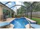 Sparkling blue pool with screened enclosure, patio, and lush greenery, creating a private and inviting outdoor oasis at 12804 Se 90Th Court Rd, Summerfield, FL 34491