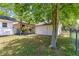 A lush backyard featuring a covered back porch, garage, and fenced yard at 1405 Ne 55Th St, Ocala, FL 34479