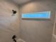 This bathroom tub and shower features white marble pattern tile, a rain shower head, and a window at 14437 Sw 21St Pl, Ocala, FL 34481