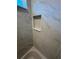 This white marble pattern tile bathroom features a shower niche for storage and organization at 14437 Sw 21St Pl, Ocala, FL 34481
