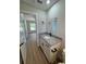 Bathroom with vanity, granite countertop, wood-look flooring, modern fixtures, and a view to the bedroom at 14437 Sw 21St Pl, Ocala, FL 34481