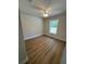 This bedroom has wood-look flooring, a neutral color scheme, and a bright window view to the exterior at 14437 Sw 21St Pl, Ocala, FL 34481