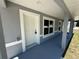 The front porch features gray flooring, a white front door, and a newly painted exterior at 14437 Sw 21St Pl, Ocala, FL 34481