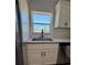 Kitchen sink with granite countertops and white cabinetry is illuminated by natural light at 14437 Sw 21St Pl, Ocala, FL 34481