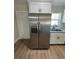 This is a stainless steel fridge beside the kitchen sink with granite countertops and white cabinetry at 14437 Sw 21St Pl, Ocala, FL 34481