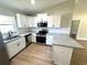 The modern kitchen features white cabinets, stainless steel appliances, and a granite countertop at 14437 Sw 21St Pl, Ocala, FL 34481