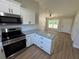 Bright kitchen featuring white cabinets, granite countertops, and stainless steel appliances at 14437 Sw 21St Pl, Ocala, FL 34481