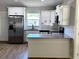 The modern kitchen features white cabinets, stainless steel appliances, and a granite countertop at 14437 Sw 21St Pl, Ocala, FL 34481