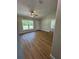 Bright living room features wood-look flooring, ceiling fan, and natural light from a large window at 14437 Sw 21St Pl, Ocala, FL 34481