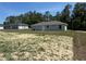 A simple home with a cozy backyard on a sunny day with a grey exterior at 14443 Sw 21St Pl, Ocala, FL 34481