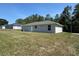 A simple home with a cozy backyard on a sunny day with a grey exterior at 14443 Sw 21St Pl, Ocala, FL 34481