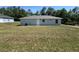 A simple home with a cozy backyard on a sunny day with a grey exterior at 14443 Sw 21St Pl, Ocala, FL 34481