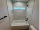 Bathroom featuring a bathtub with marble-patterned tile surround and a shower niche at 14443 Sw 21St Pl, Ocala, FL 34481