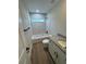 Modern bathroom featuring a bathtub with marble-patterned tile surround and gray granite vanity top at 14443 Sw 21St Pl, Ocala, FL 34481