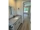 Bathroom featuring modern gray granite vanity and view into the adjacent room at 14443 Sw 21St Pl, Ocala, FL 34481