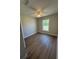 This bedroom features neutral paint, wood look floors, white trim and a large window at 14443 Sw 21St Pl, Ocala, FL 34481