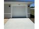 A close up of a garage door with paneling, clean white trim, and concrete driveway at 14443 Sw 21St Pl, Ocala, FL 34481