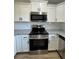 Kitchen featuring granite countertops, white cabinetry, stainless steel stove, and microwave at 14443 Sw 21St Pl, Ocala, FL 34481