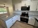 Open concept kitchen featuring an island, stainless steel appliances, and granite countertops at 14443 Sw 21St Pl, Ocala, FL 34481