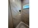 Close-up of shower with marble-patterned tile surround and shower niche at 14443 Sw 21St Pl, Ocala, FL 34481