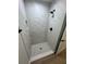 Elegant bathroom shower showcases a white marble tile surround and pebble tile flooring at 14443 Sw 21St Pl, Ocala, FL 34481