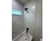 Modern bathroom with a shower featuring marble-patterned tile and matte black hardware at 14443 Sw 21St Pl, Ocala, FL 34481