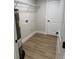 Utility room with water heater, wire rack shelving, and wood-look floors at 14443 Sw 21St Pl, Ocala, FL 34481