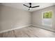 Bedroom featuring wood-look floors, neutral paint, a ceiling fan, and a large window at 15368 Sw 30Th St, Ocala, FL 34481