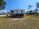Two-story home featuring a screened-in patio and a spacious backyard bordered by lush trees at 18 Fir Trail Dr, Ocala, FL 34472