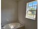 A bright bathroom featuring a soaking tub with a window view at 18 Fir Trail Dr, Ocala, FL 34472