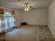 Spacious living room with a ceiling fan and large window with decorative curtains at 18 Fir Trail Dr, Ocala, FL 34472