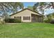 View of a home's backyard featuring a screened lanai, lawn, and mature trees at 2008 Tweed Ct, Leesburg, FL 34788