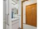Bright bathroom features a skylight, updated sink and countertop, and a wooden entry door at 2008 Tweed Ct, Leesburg, FL 34788