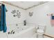 All-white bathroom with a large tub, toilet, and decorative wall art at 2008 Tweed Ct, Leesburg, FL 34788