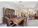 Open concept dining room with a dark wood table, plenty of seating, and access to the kitchen at 2008 Tweed Ct, Leesburg, FL 34788