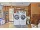 Spacious laundry room featuring washer, dryer, utility sink and ample storage shelves at 2008 Tweed Ct, Leesburg, FL 34788