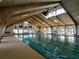Indoor swimming pool with vaulted wood ceilings and natural light; an inviting space for year-round exercise and leisure at 2008 Tweed Ct, Leesburg, FL 34788