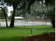 Well-maintained tennis court surrounded by lush greenery, offering a perfect spot for outdoor recreation at 2008 Tweed Ct, Leesburg, FL 34788