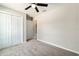 Neutral bedroom featuring carpeted floors, a ceiling fan, and a double door closet for ample storage at 20443 Sw Rainbow Lakes Blvd, Dunnellon, FL 34431