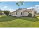 Well-maintained backyard with lush lawn, tasteful landscaping, and beige siding home at 2208 Orkney Dr, Leesburg, FL 34788