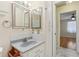 Bathroom with vanity area featuring dual mirrors, storage, and access to bedroom at 2208 Orkney Dr, Leesburg, FL 34788