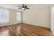 A bright bedroom featuring hardwood floors, white trim, and filled with light from two windows at 2208 Orkney Dr, Leesburg, FL 34788