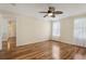 Bright bedroom featuring hardwood floors, white trim, filled with light and views into other rooms at 2208 Orkney Dr, Leesburg, FL 34788