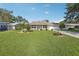 Charming single-story home with a well-manicured lawn and mature landscaping at 2208 Orkney Dr, Leesburg, FL 34788