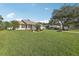 Single Gathering home featuring a lush lawn, mature trees, and inviting curb appeal at 2208 Orkney Dr, Leesburg, FL 34788
