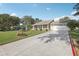 Inviting home with a long driveway and well-maintained front lawn and garden at 2208 Orkney Dr, Leesburg, FL 34788