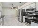 Kitchen features stainless steel appliances, marble floor, and modern cabinets at 2208 Orkney Dr, Leesburg, FL 34788